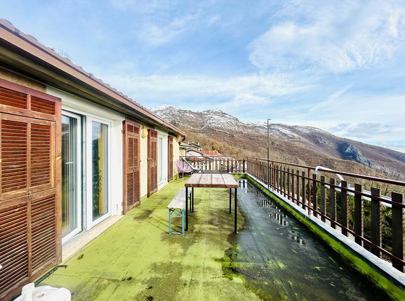 Portion of a house with a terrace overlooking the sea.